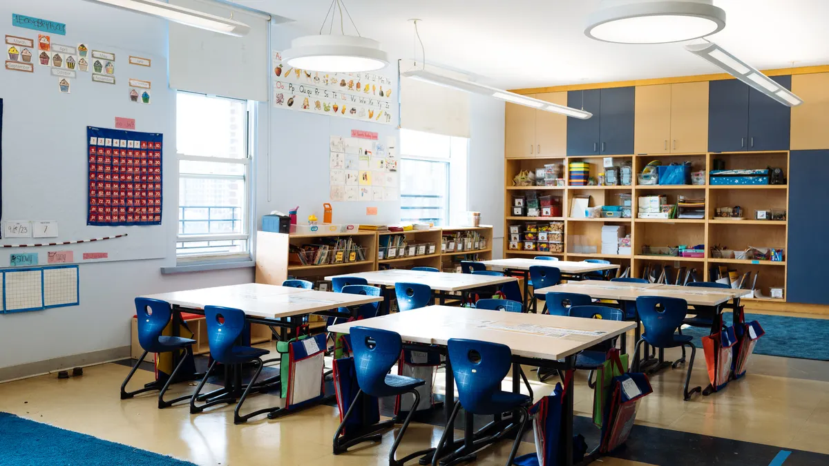 A classroom with desks and supplies sits empty