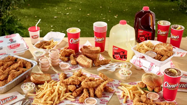 A bunch of chicken fingers, fries, toast slices, lemonade and iced tea on a picnic blanket.