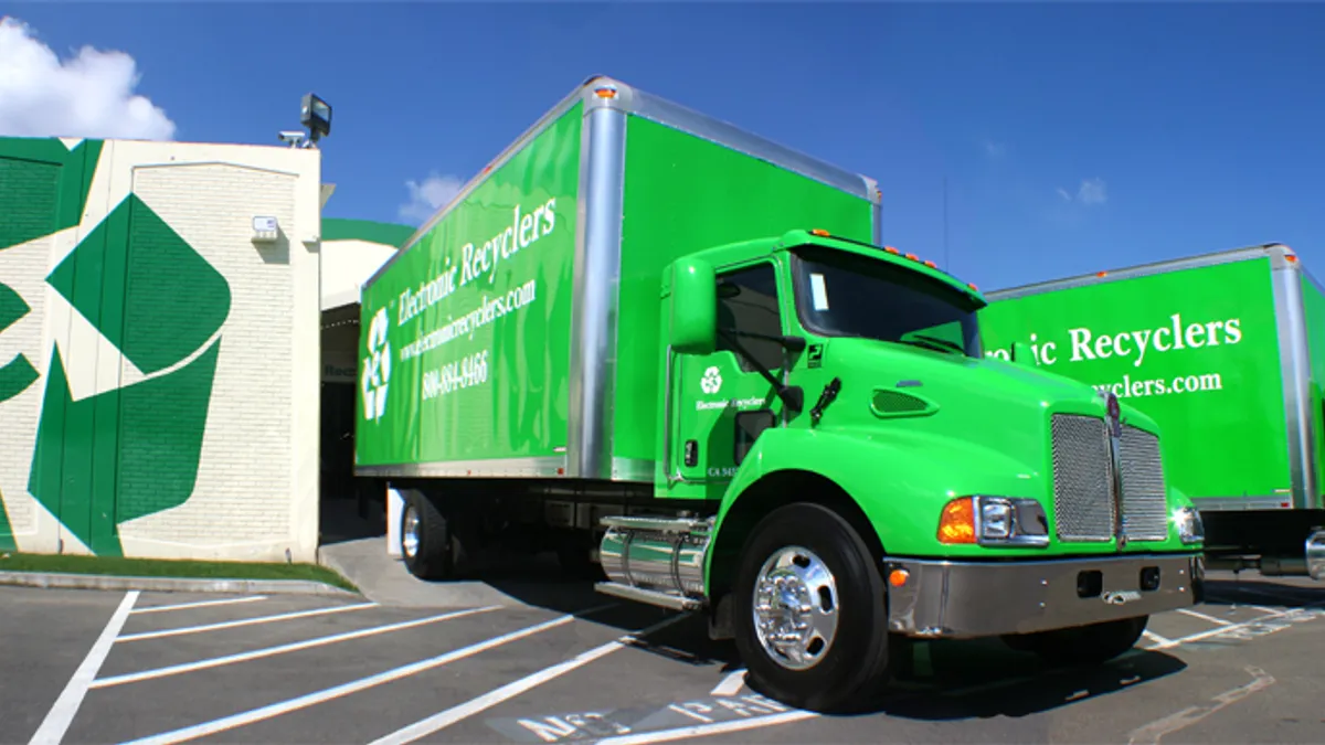 Green ERI trucks pull out of a facility