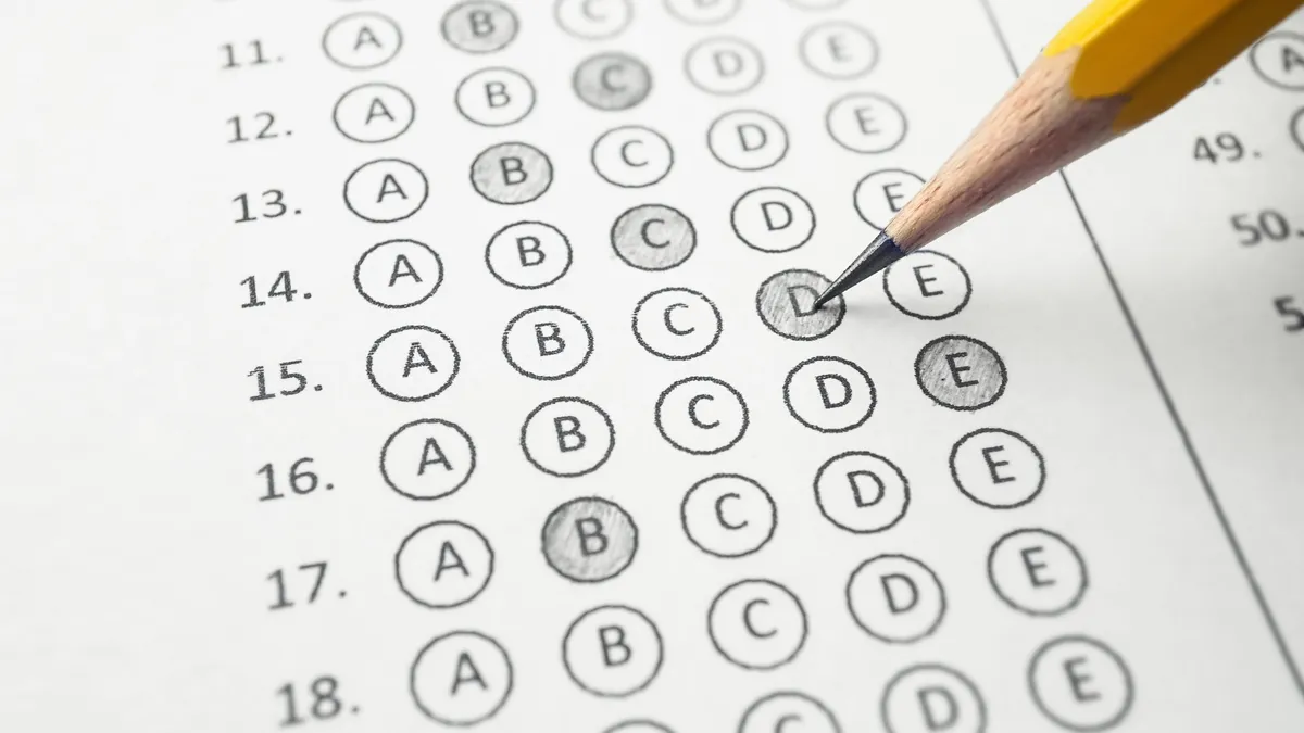 A bubble answer sheet is shown with some answers bubbled in. A pencil is near the sheet