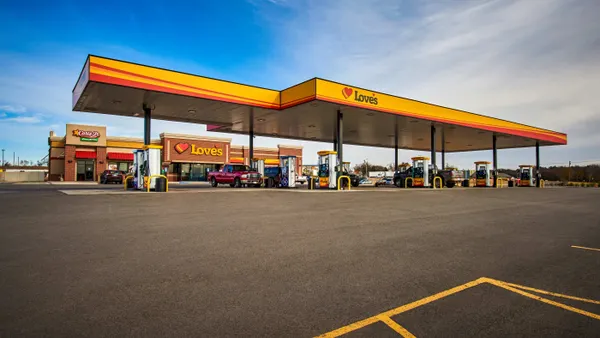 A photo of the exterior of a gas station and convenience store. Signs on the building say Carl's Jr. and Love's.