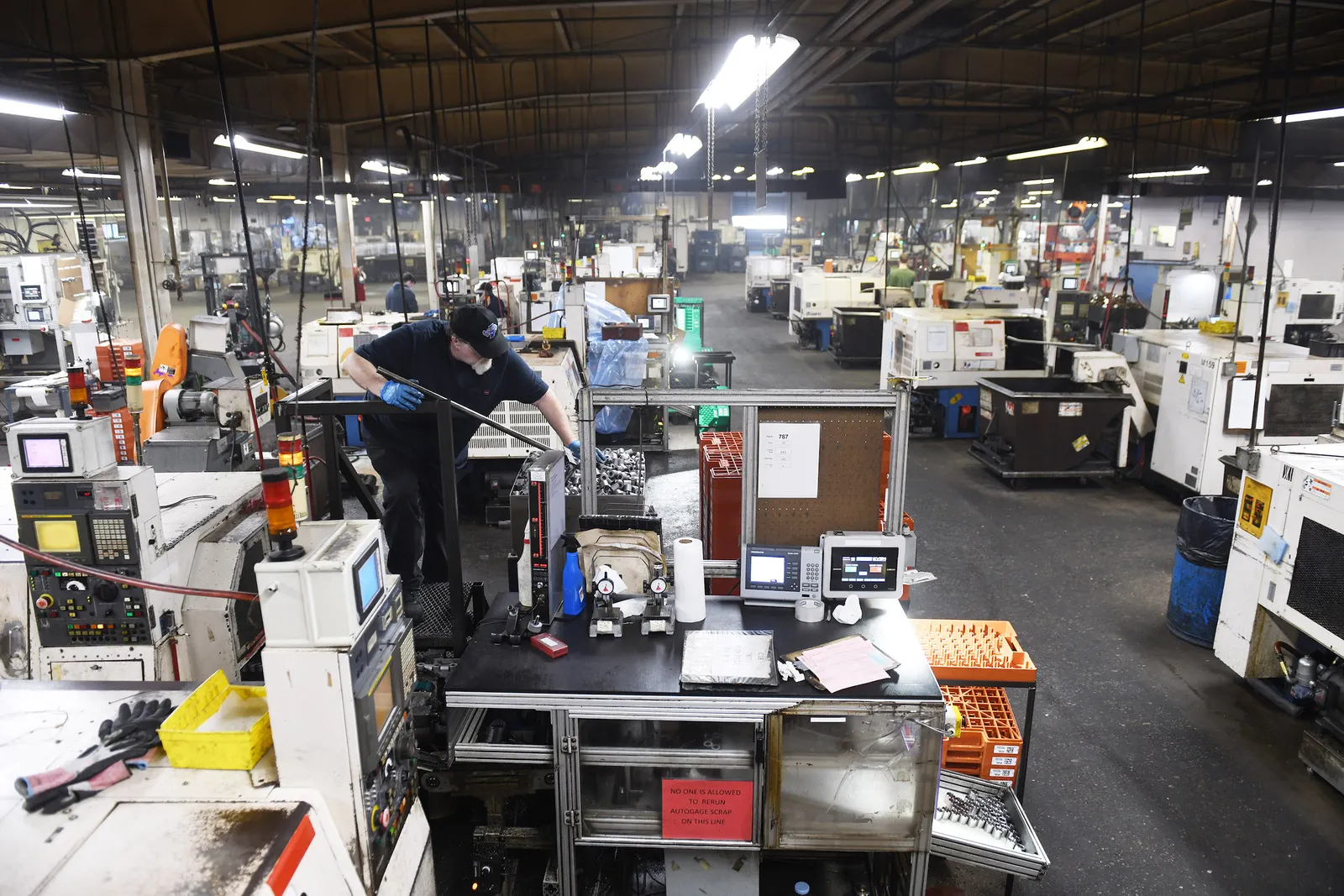 A person stands over a bin of metal parts at a Morris Manufacturing facility
