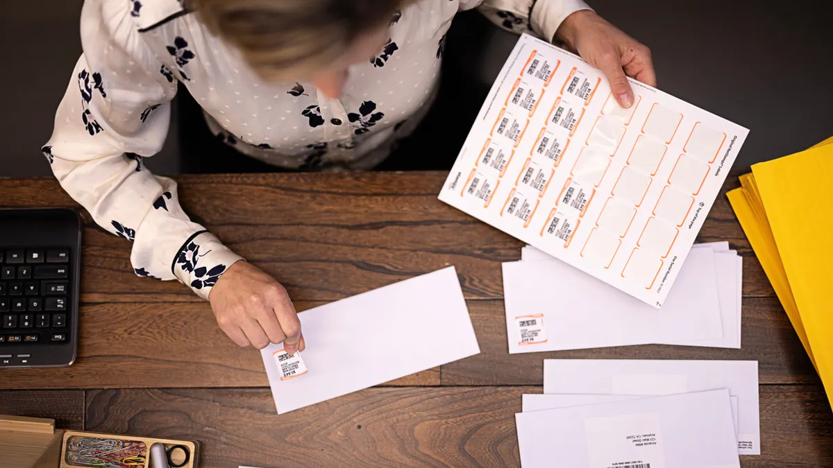 Overhead view of person placing a stamp on a letter