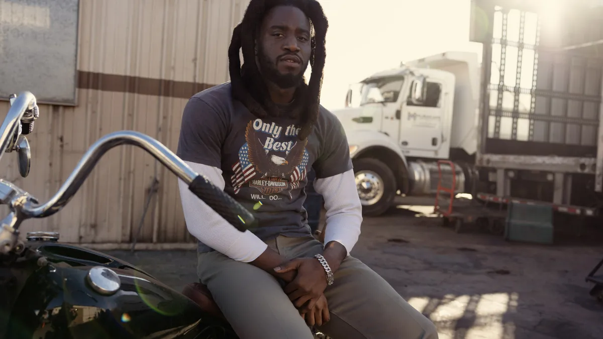 Person wearing Harley Davidson apparel sits on a motorcycle.