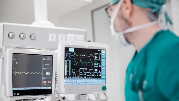 Male surgeon looking at the monitoring equipment during surgery.