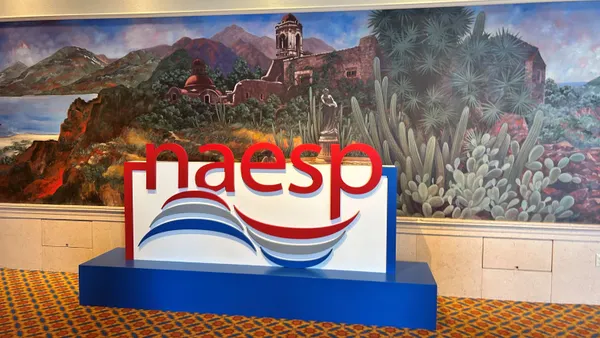 A large sign that says "NAESP" stands in a convention center hallway.