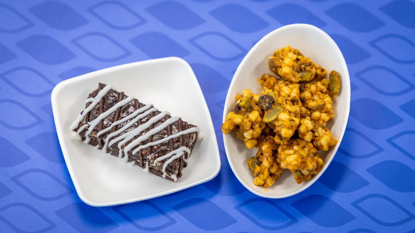 A chocolate cherry cordial bar on a plate is next to a snack cluster.