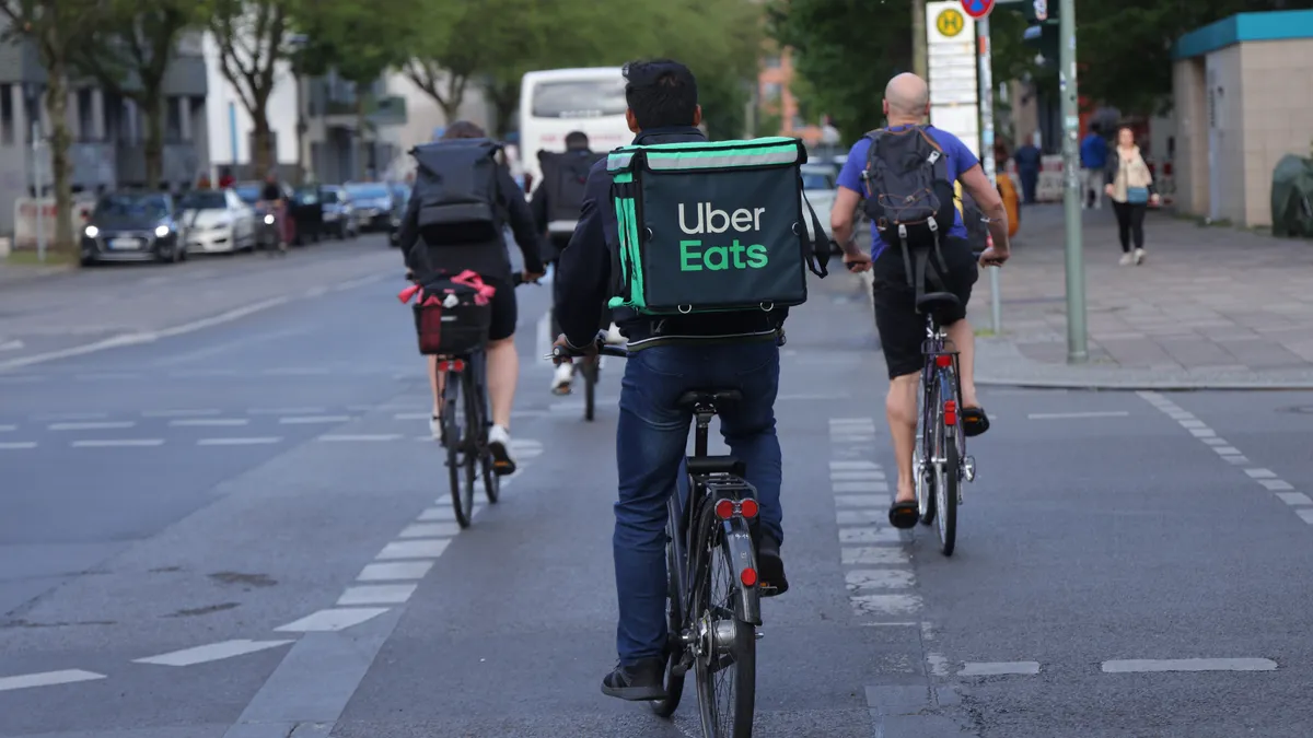 The back of a bike courier with an Uber Eats bag.