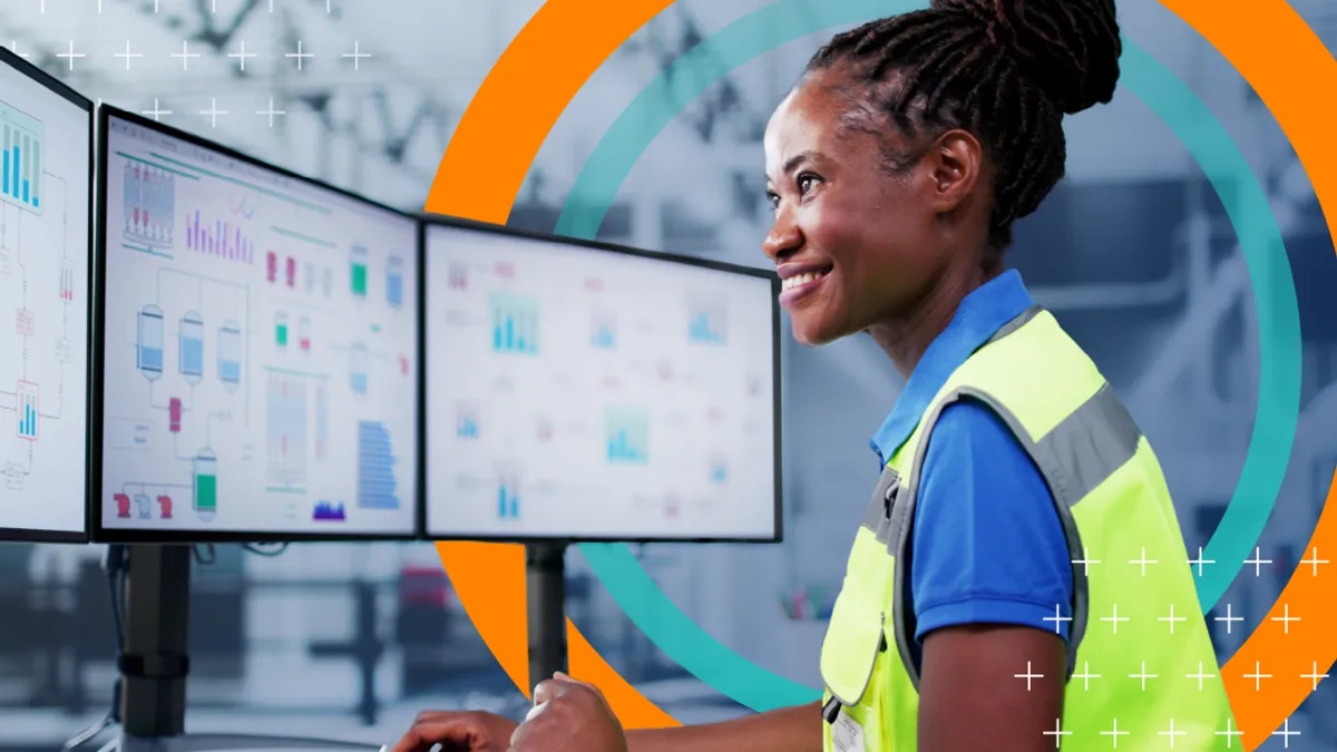 Woman in yellow vest working at computer desk