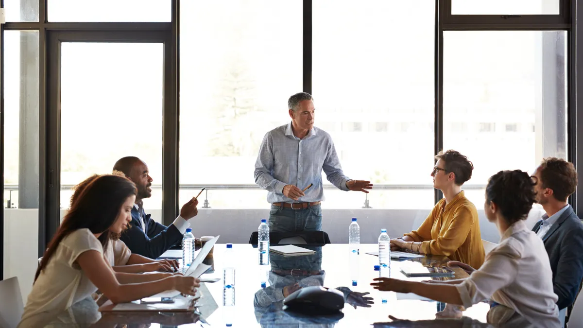 CEO making briefing in conference room with glass table