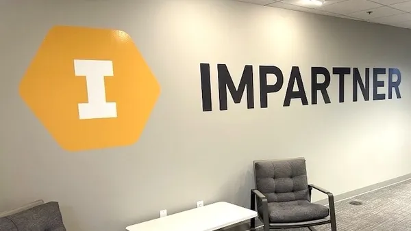 The interior of an office with the corporate logo for Impartner painted on the wall.