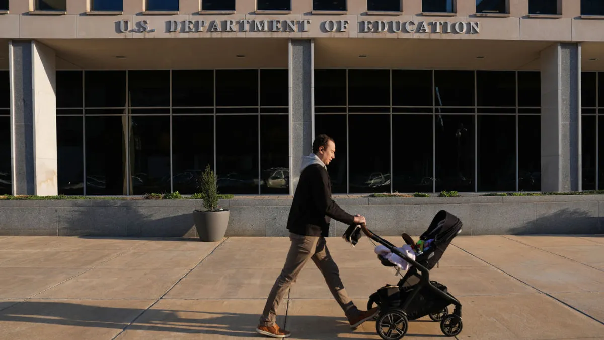 A person pushed a baby stroller past the outside of the U.S. Department of Education's building.