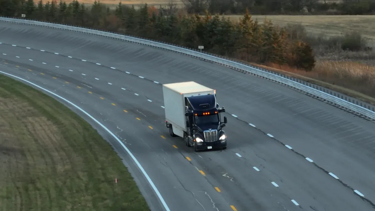 An Aurora tractor-trailer drives without a human driver, navigating a turn at TRC Ohio, a private test track