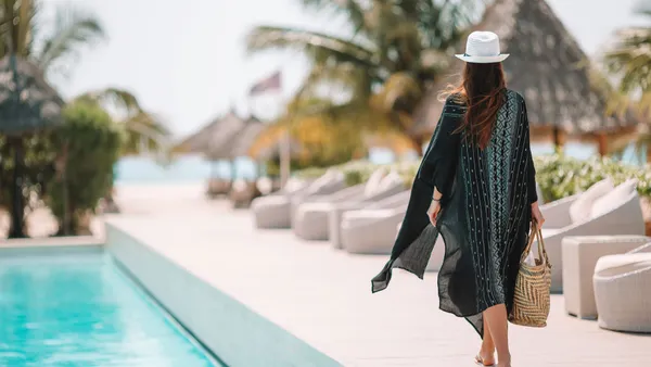 Woman relaxing by the pool in a luxury hotel resort enjoying perfect beach holiday vacation