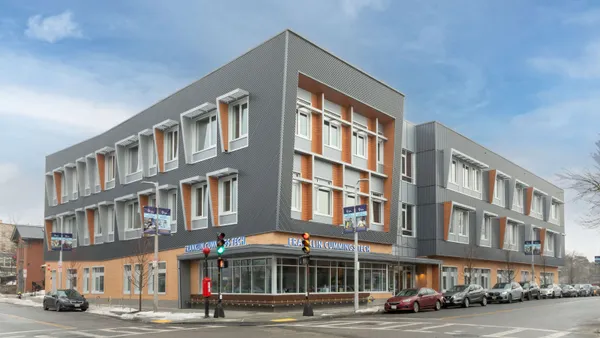 The exterior of a modern building located on a street corner.