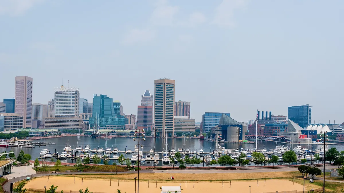 Boats docked in a harbor with tall buildings in the background.