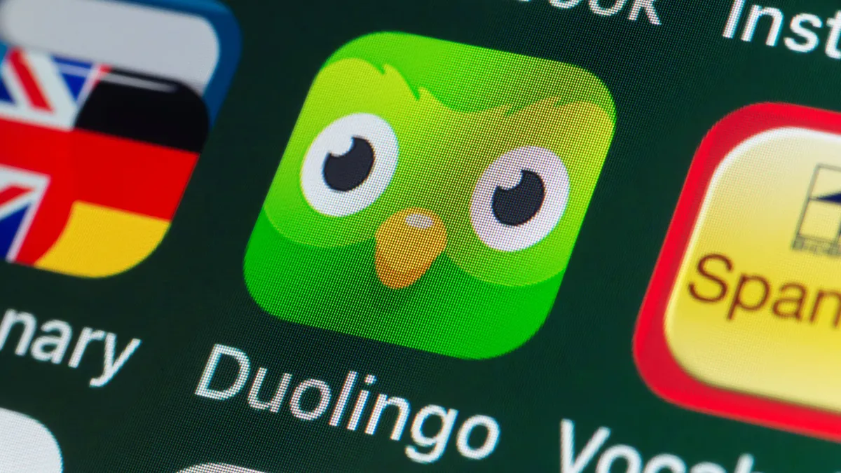 The buttons of the app Duolingo, surrounded by Dictionary, Vocabulary, Facebook on an iPhone screen.