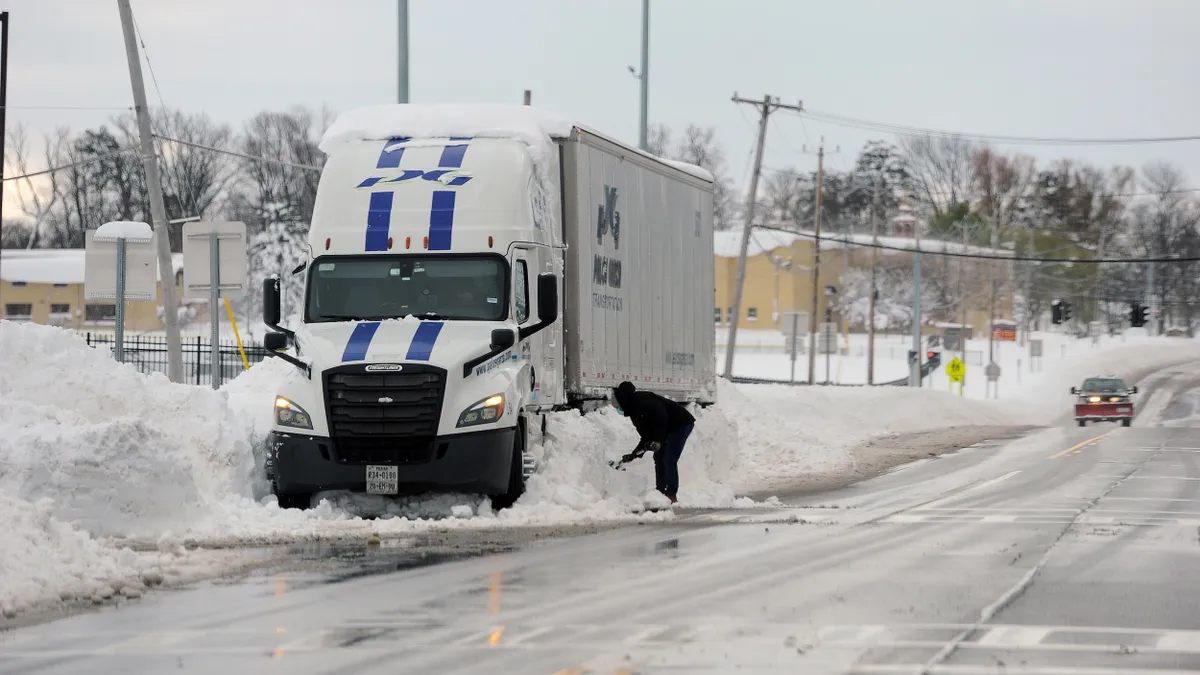 A truck driver shovels snow after an intense lake-effect snowstorm in Hamburg, New York, in November 2022.