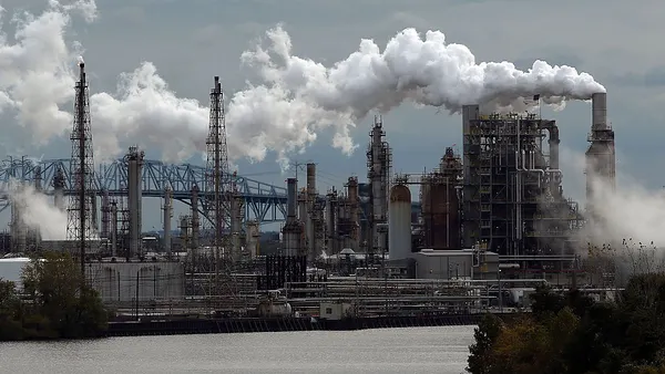 An image of the largest crude oil by rail unloading terminal in the United States with smoke billowing out of multiple smokestacks.