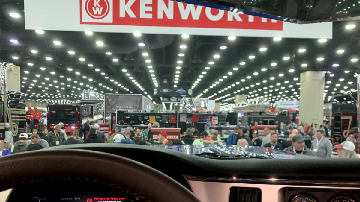 Attendees of the Mid-America Trucking Show in Louisville, Kentucky, pass by a Kenworth vendor booth.