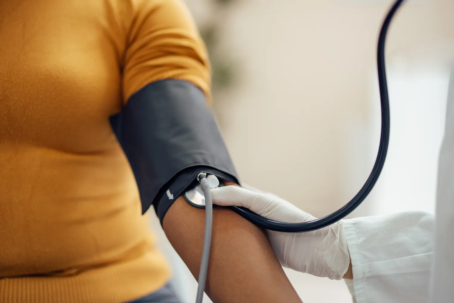 A medical professional measures a patient's blood pressure using a sphygmomanometer.