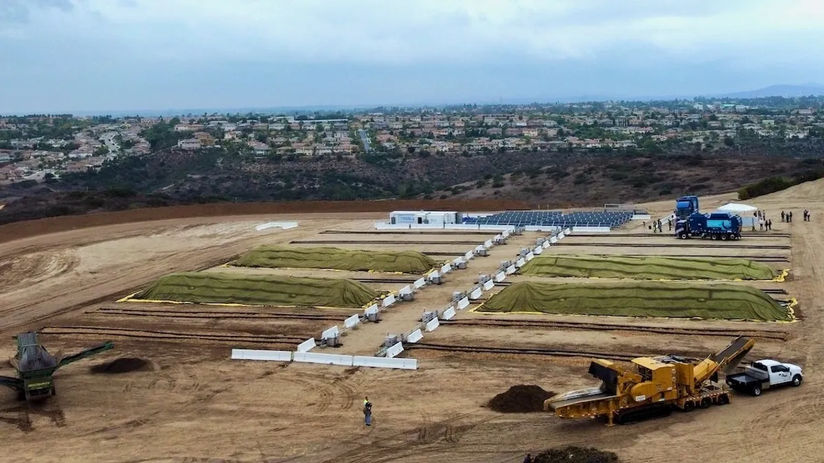 Aerial view of composting facility at landfill, with residential area in the background