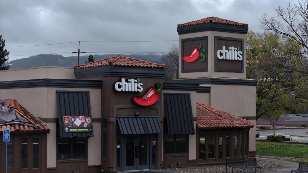 An image of a restaurant that has a white sign with "Chili's" on the front and side.