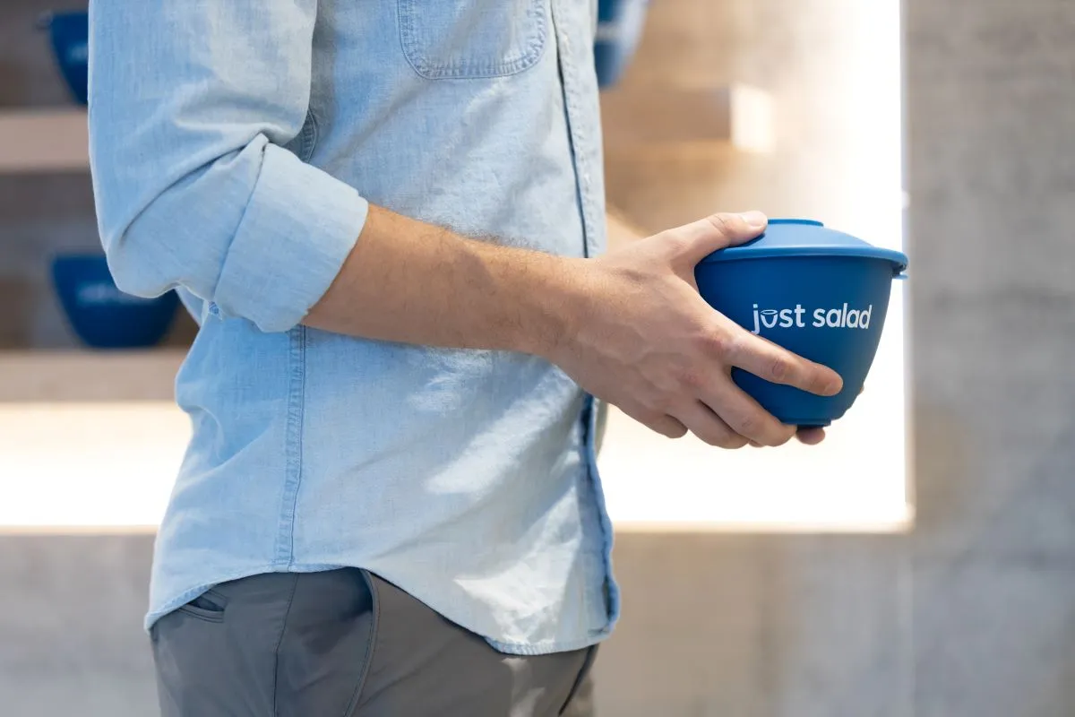 A picture of a man holding Just Salad's reusable bowl