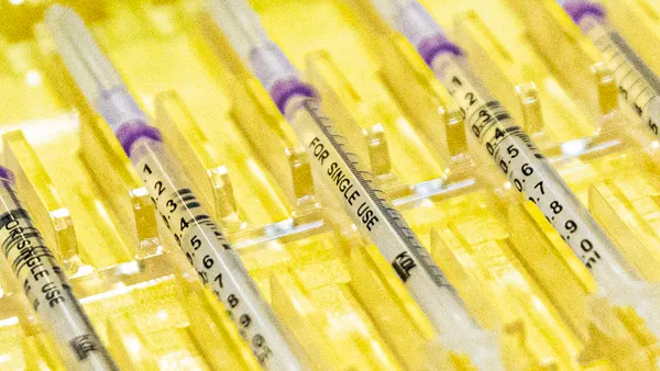 Prepared syringes are lined up in a yellow tray.