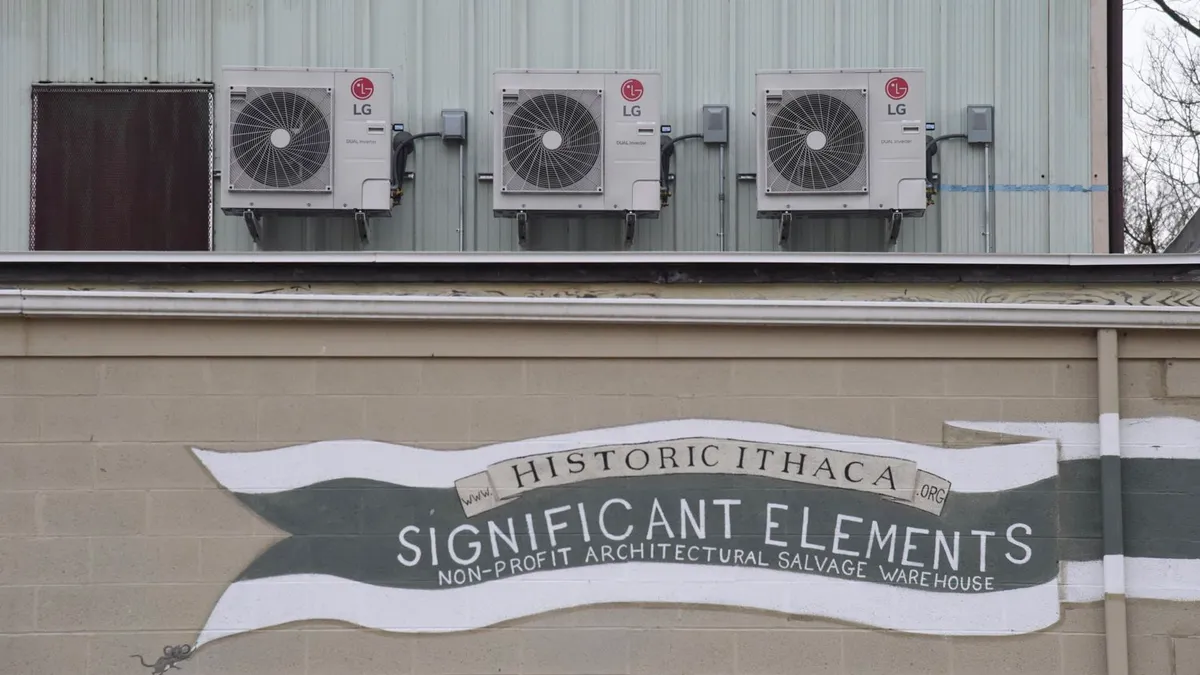 A facade of Historic Ithaca, an architectural warehouse, with three LG air-source heat pumps in the background.