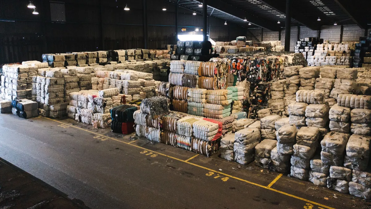 Bulk fabric ready for recycling sits in warehouse.