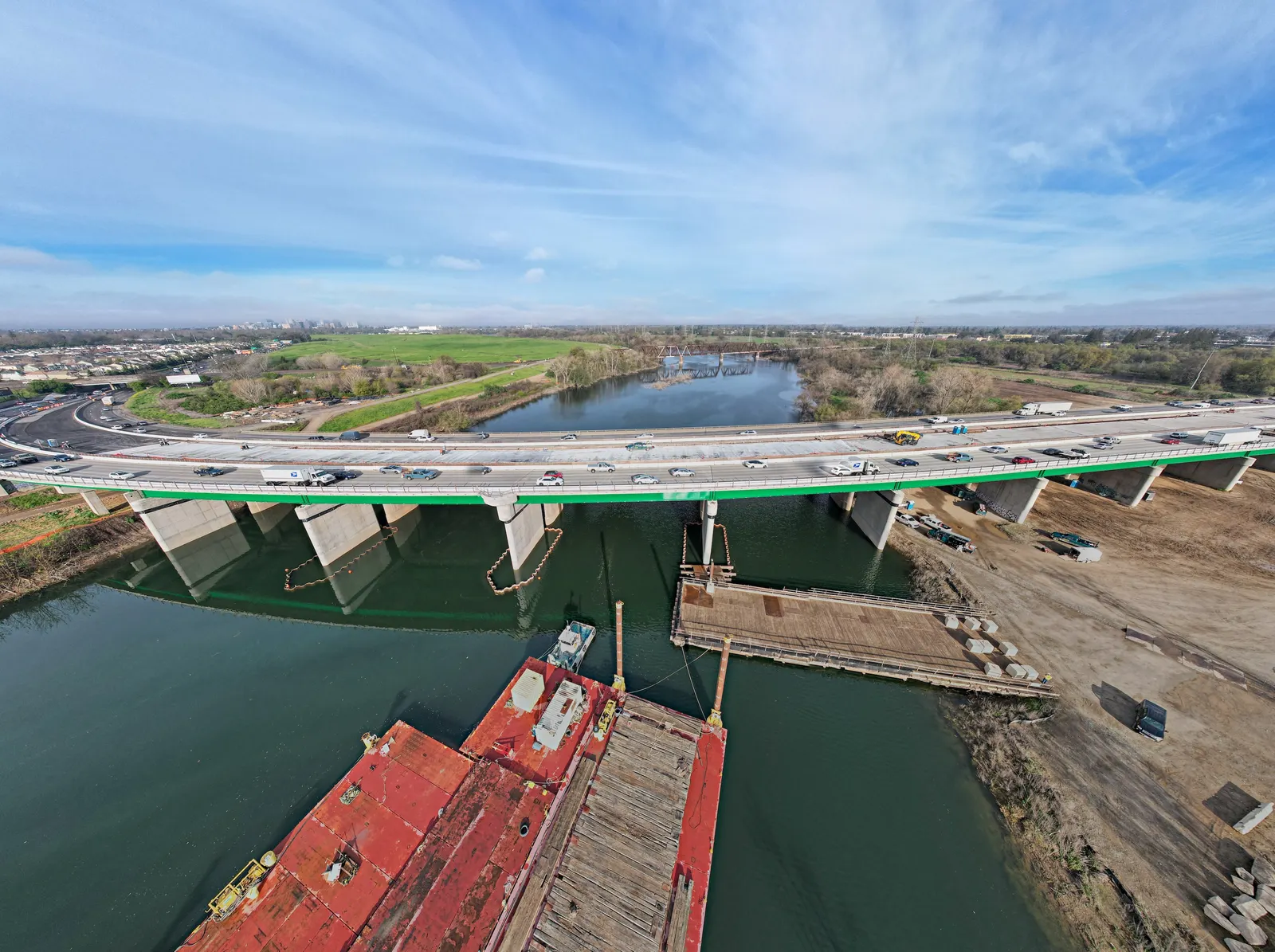 An aerial view shows a completed bridge deck spanning the American River in California.