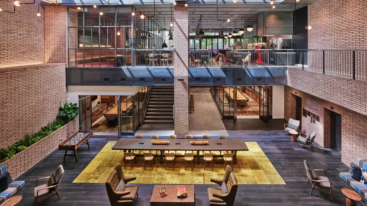 An aerial view of people on yellow couches in a lobby.