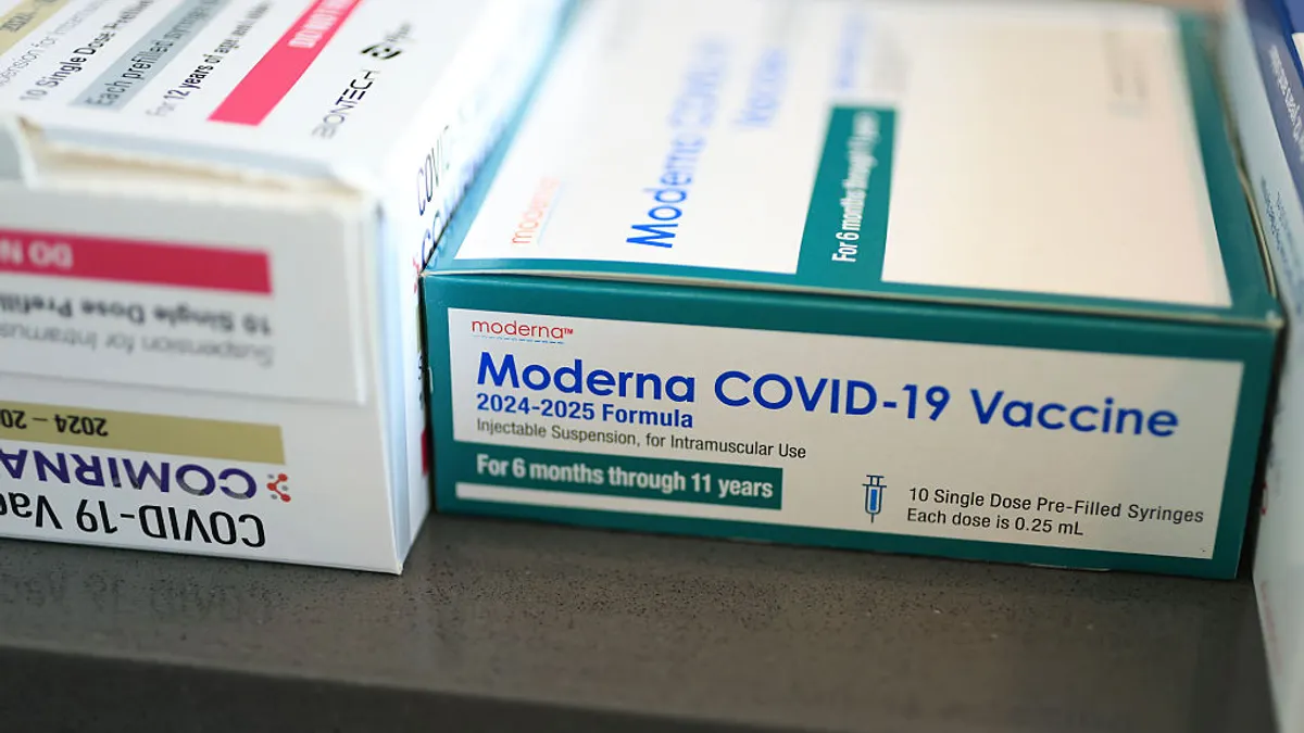 Boxes of Moderna and Pfizer COVID-19 vaccines sit by side in this photo illustration.