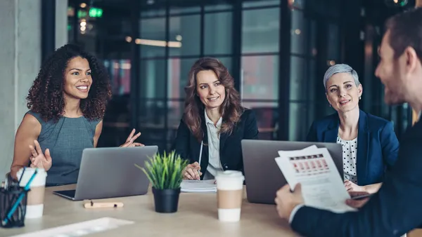 Group of business persons sitting around a table and talking
