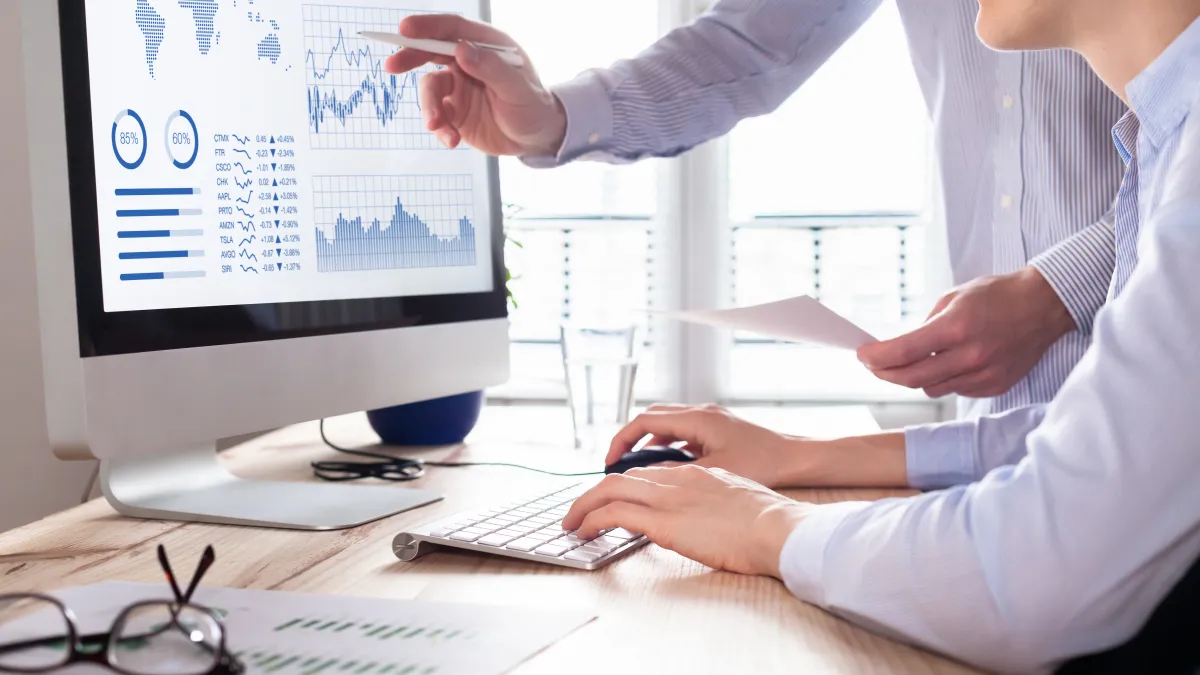 Business partners working on computer looking at a dashboard