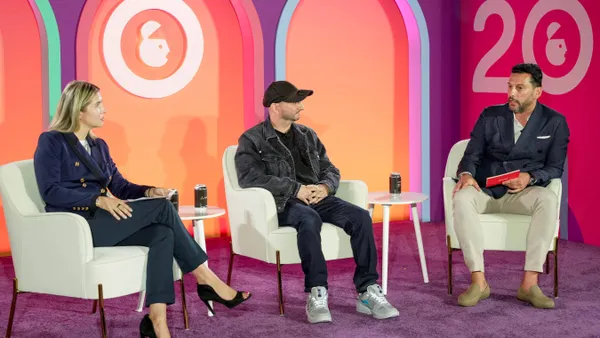 A trio of executives sit on a stage at Advertising Week New York 2024