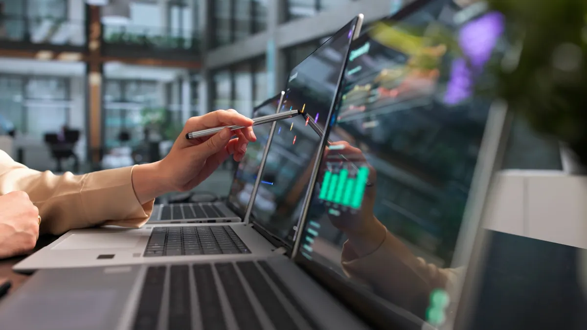 Woman reviewing cyber information on multiple computer screens.