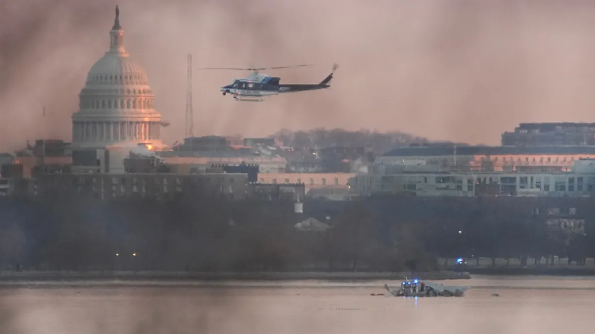 A helicopter flies near the site of the American Airlines plane crash on the Potomac River.