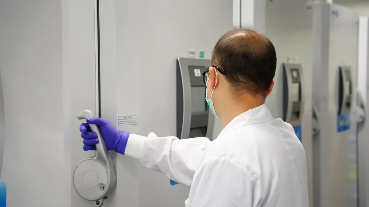 Lab worker holding equipment.
