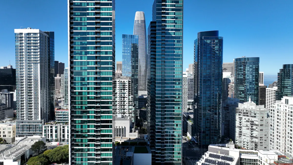 Tall buildings in a dense urban downtown against a blue sky.