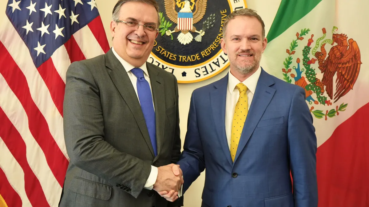U.S. President Donald Trump and Japanese Prime Minister Sanae Takaichi hold up signed documents.