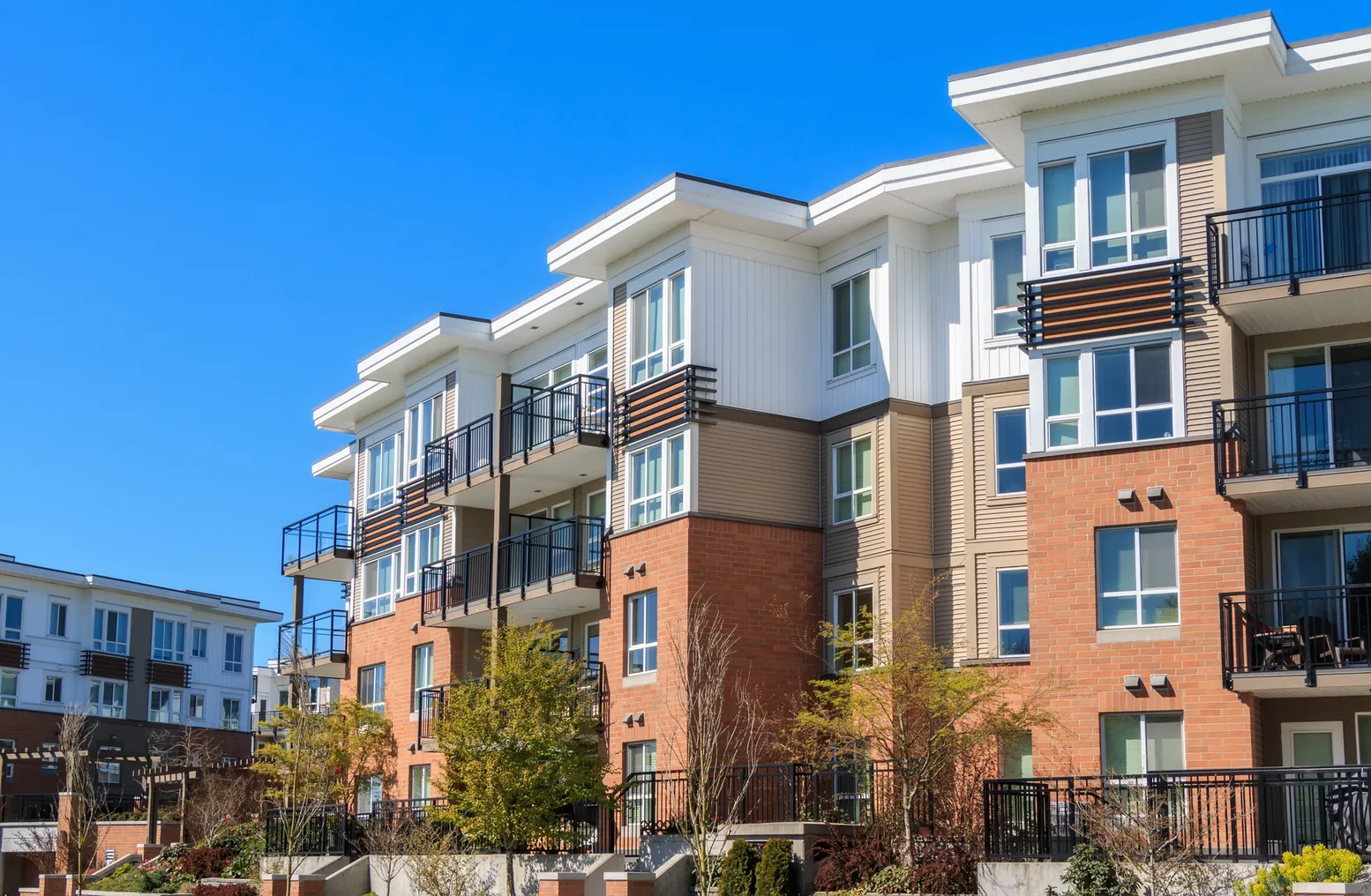 Three-story, multi-colored apartments with balconies.