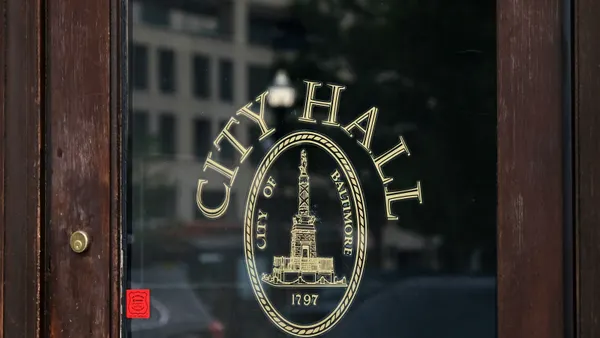 A sign on the window of a door reads "City Hall, City of Baltimore, 1797"
