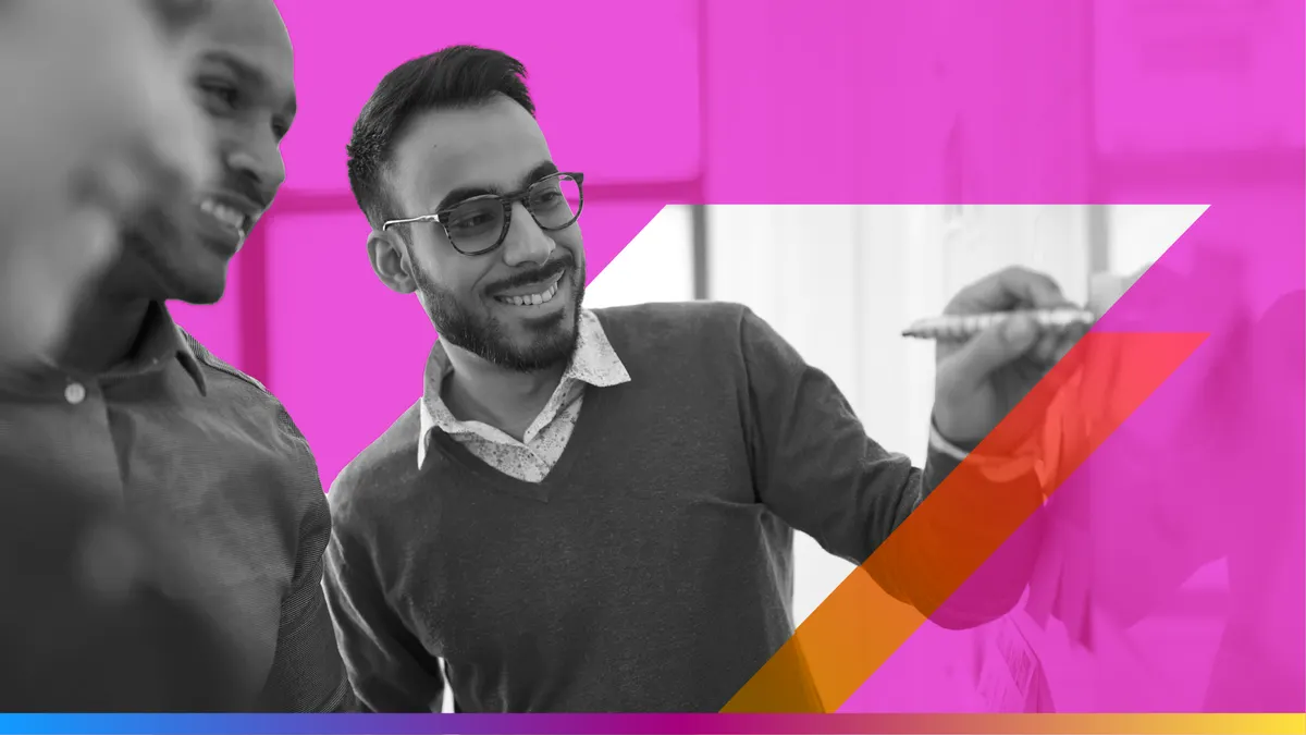 Men smiling using a whiteboard