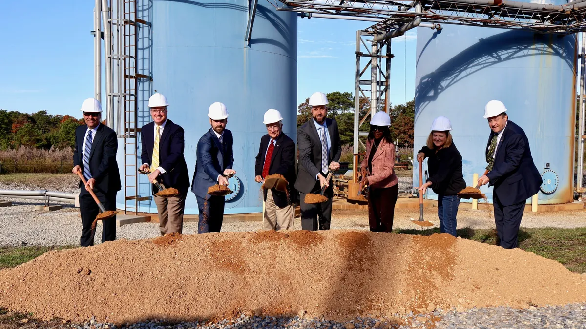 A group of people take part in a groundbreaking ceremony.