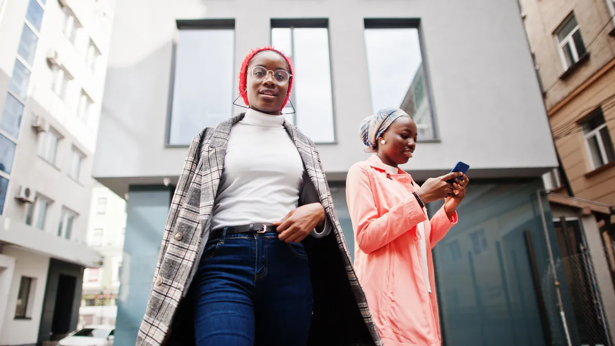 Two Black hijabi people stand for portraits on the street