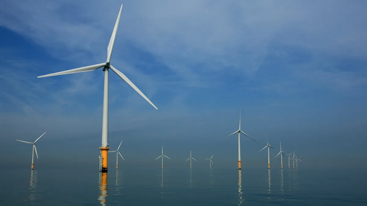 Turbines of the new Burbo Bank off shore wind farm stand in a calm sea in the mouth of the River Mersey.