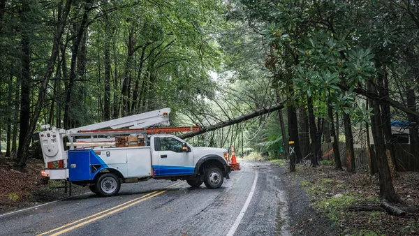 A utility truck near a downed power line.
