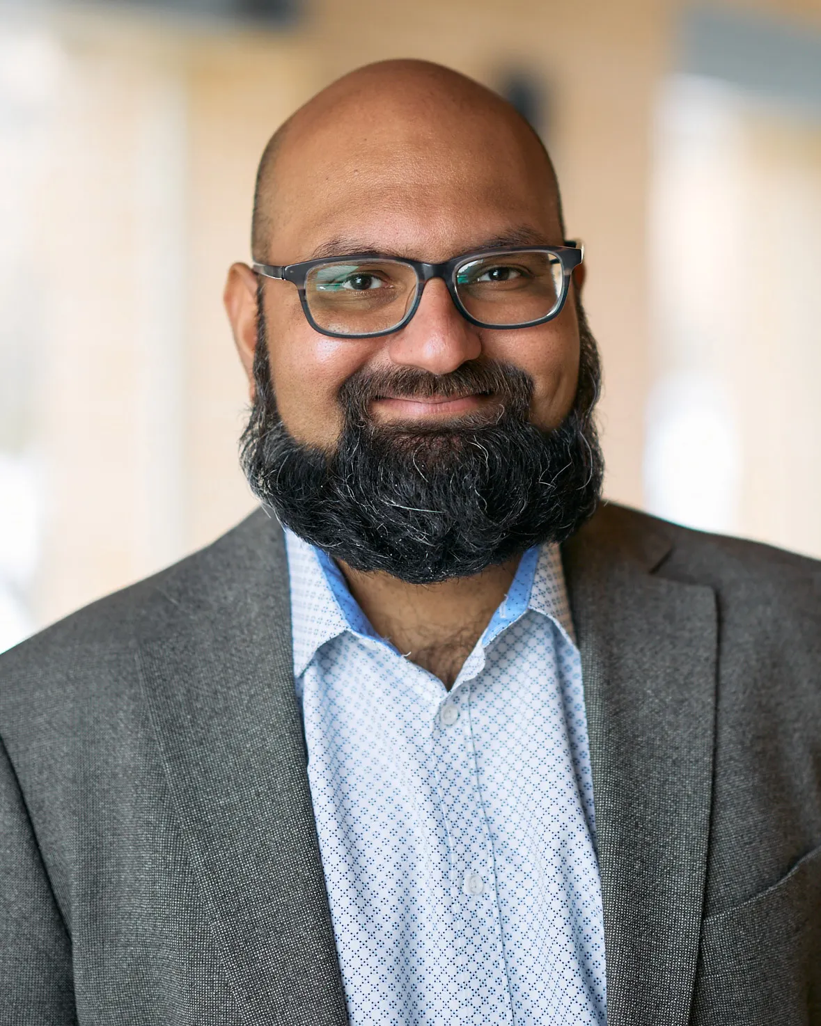 A person is looking at the camera and their head and shoulders is seen